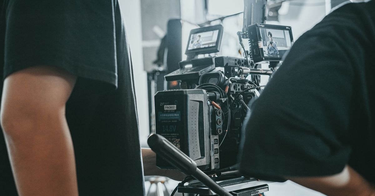 Close-up of a film crew operating professional camera equipment indoors.