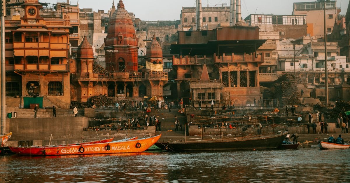 Varanasi Travel Guide: A Slow Walk Along the Sacred Ganges Manikarnika Ghat along the Ganges River in Varanasi, showcasing local architecture and spiritual significance.