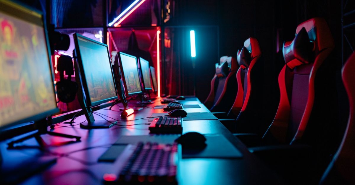 Former Jamaica Stock Exchange chief launches consultancy and stock market game for kids An immersive gaming room with neon lights, computers, and gaming chairs ready for a tournament.