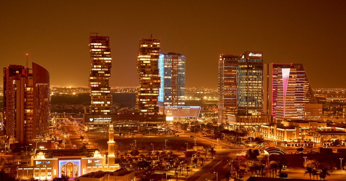Swiss International Palace Hotel Manama in Bahrain: A City-Hub Base on Gudaibiya Avenue Vibrant city skyline captured at night, showcasing beautifully lit modern architecture.
