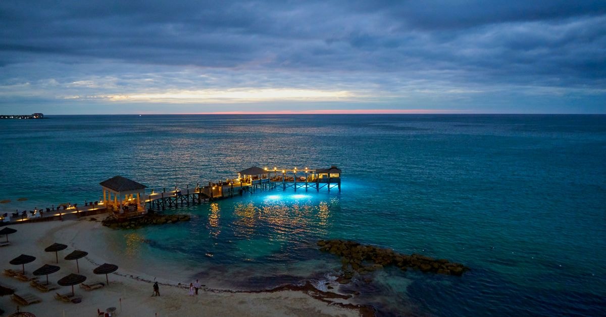 Twilight envelops the serene beach and pier in Nassau, The Bahamas, with stunning seascape views.