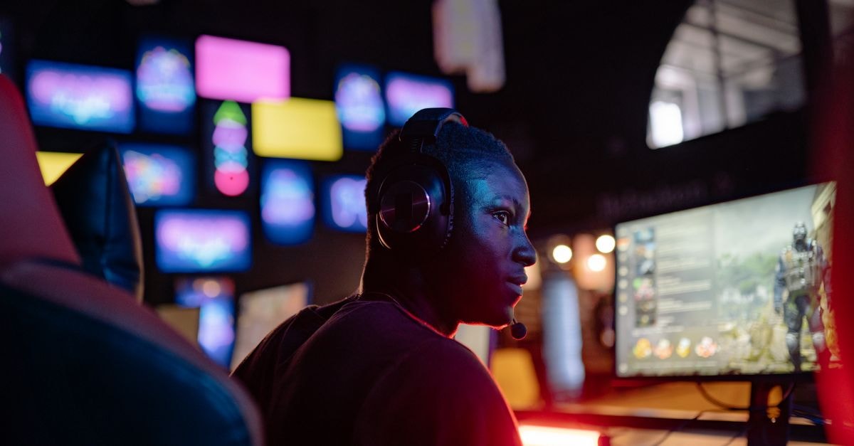 Double Fine announces chaotic bus-driving game Thank You Bus Driver for PC A young man intensely focused on a gaming session at a colorful gaming setup, wearing headphones.