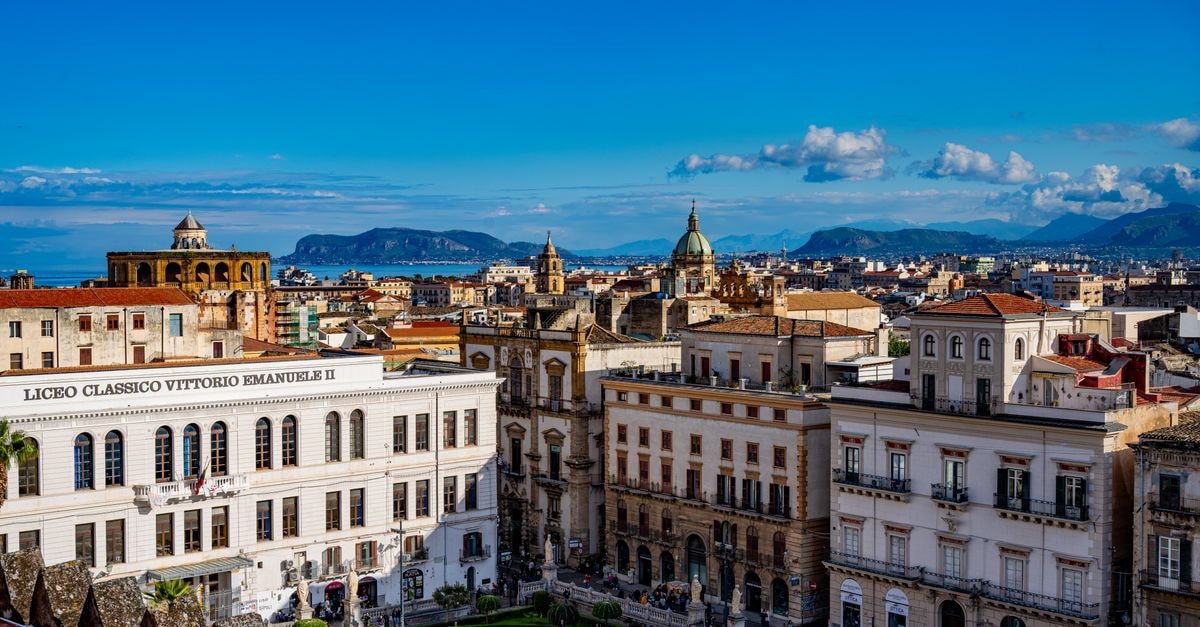 Hospitality Hotel in Palermo: A 2016 Build Inside an Early-1900s Palazzo A picturesque view of Palermo's historic architecture under a bright blue sky in Sicily, Italy.