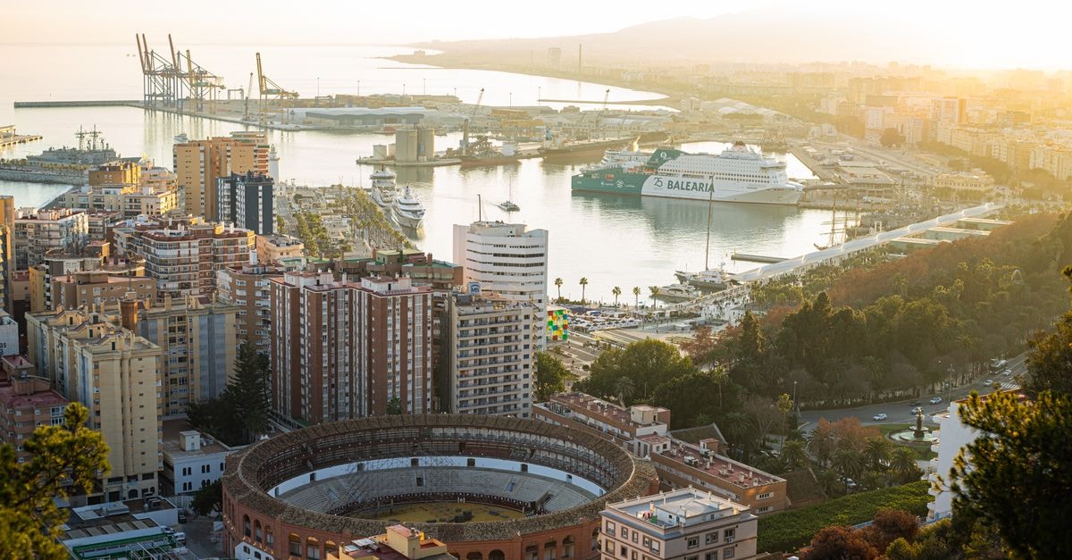 Rendez-Vous Hotel in Port-de-Paix: A Caribbean Retreat Stunning aerial shot of Malaga featuring the bullring and busy harbor at sunset.