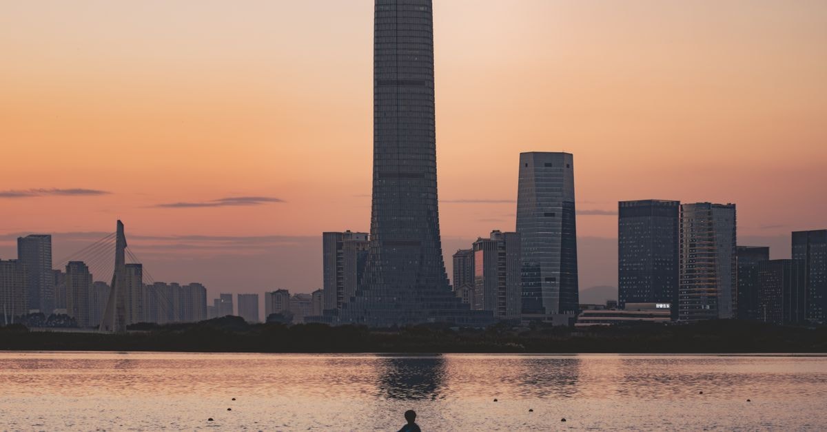 Hotel Soul, Suzhou — Contemporary Boutique Stay by Canals and Gardens A silhouette of a kayaker at sunset against a city skyline, capturing tranquility and urban life.
