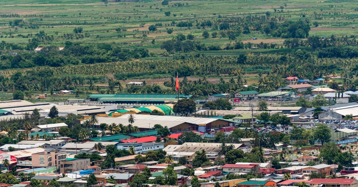 Hospedaria FC, Cabinda: A Central Stay Near Sé Catedral Vibrant aerial shot of Tunapuna, showcasing colorful buildings and lush green fields in Trinidad and Tobago.