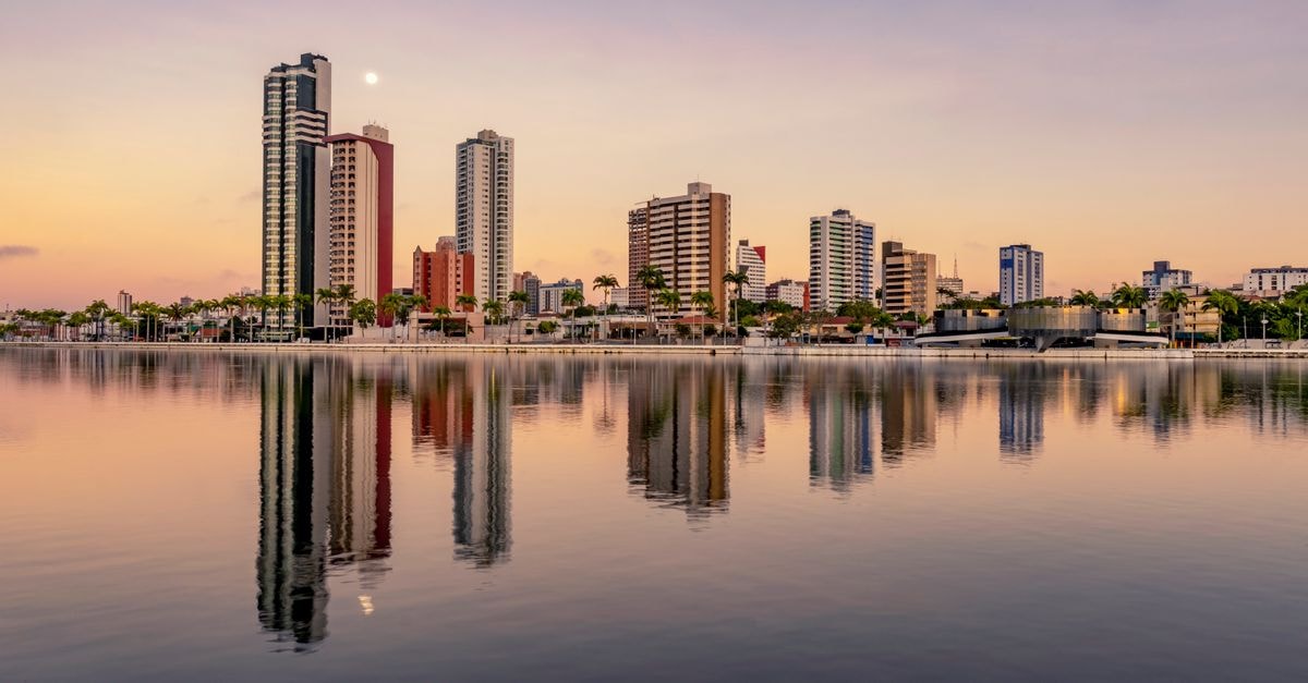 Novotel Recife Marina in Recife: A Modern Seafront Stay on the Waterfront Picturesque scenery of coherent tall modern buildings of contemporary megalopolis near calm river in sunset in dusk