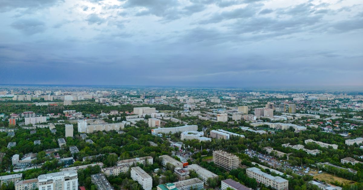Novotel Bishkek City Center: Capital Core with Mountain and City Panoramas A stunning aerial shot of Bishkek, Kyrgyzstan, showcasing its vibrant cityscape and greenery.