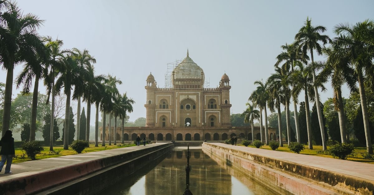 The Royal Plaza, New Delhi: 419-Room Connaught Place Stay Explore the architectural beauty of Safdarjung Tomb surrounded by palm trees and a tranquil pond in New Delhi, India.