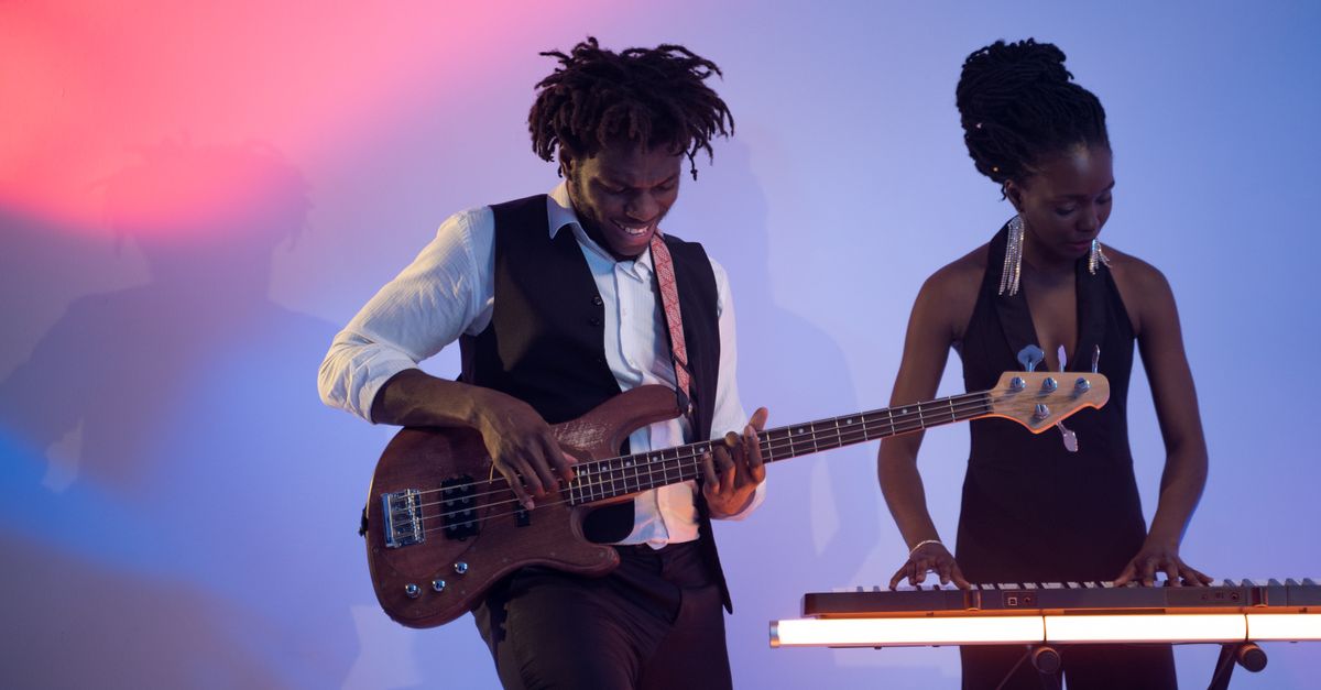 America's Got Talent: Sarah Hardwig and Joel Mawhinney Among Standout Acts Advancing on NBC Competition Two musicians performing passionately in a vibrant studio setting with bass guitar and keyboard.