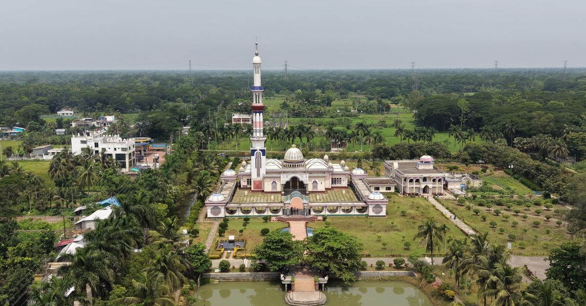 Comilla Travel Guide: Planning Tips, Costs and Things to Do Aerial shot of the Mosjidul Hakimia mosque surrounded by lush greenery in Barisal, Bangladesh.