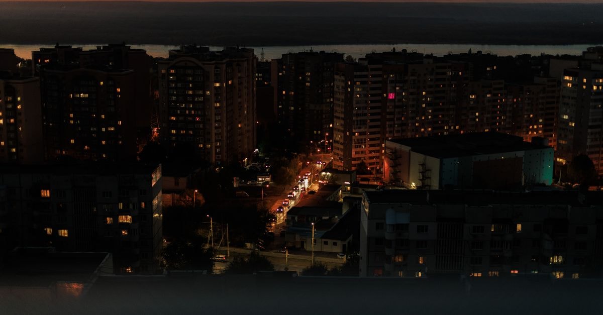 Hotel Florentina in Constanța: 33 Rooms Near the Seafront Boulevard Elevated view of a city skyline during dusk with building lights glowing and a vivid sunset.