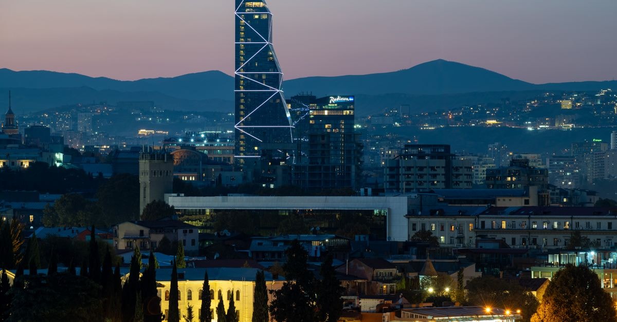 Villa Tiflisi in Tbilisi: A Quiet August 2018 Hideaway Near the Aerial Tramway The stunning Tbilisi skyline at twilight featuring a landmark modern tower illuminated against the backdrop of hills.