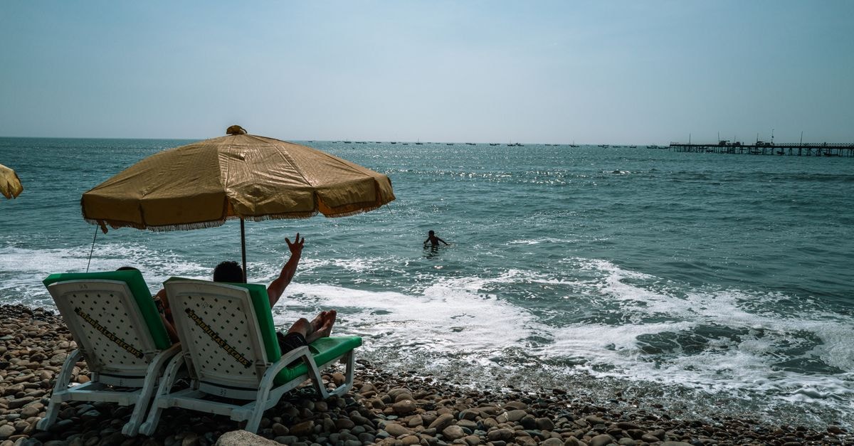 Visiting Piura: A Slow Travel Guide to Peru's Sun-Bathed North A peaceful day by the sea in Pacasmayo, with lounge chairs and sun umbrella.