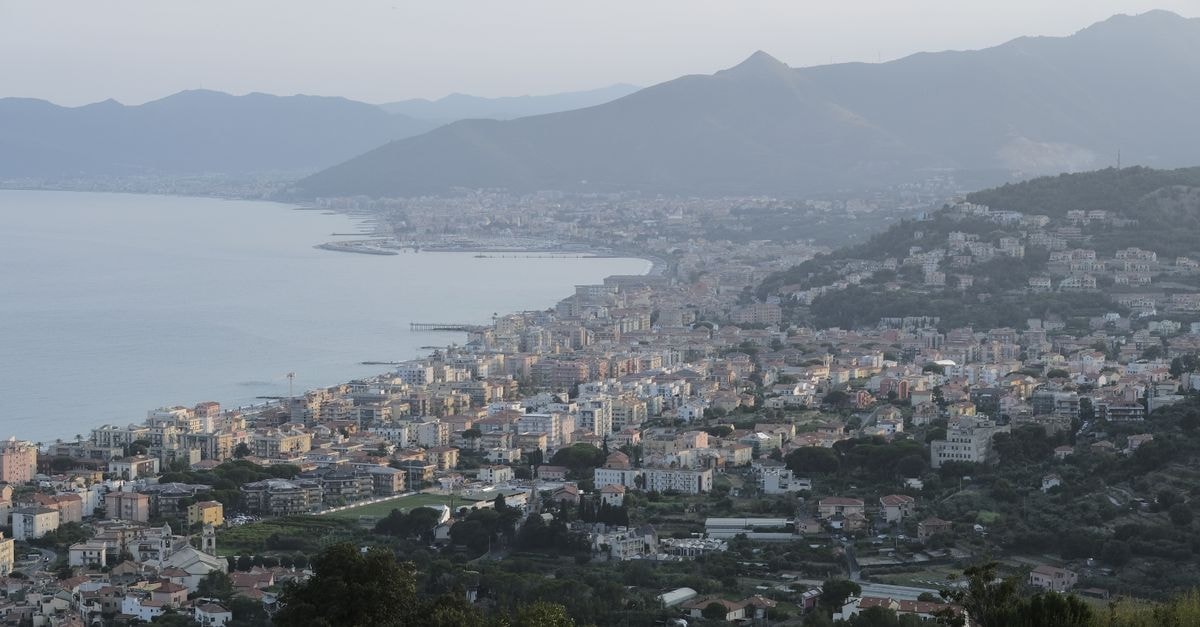 A breathtaking view of a coastal city in Italy with mountains and sea in the background.