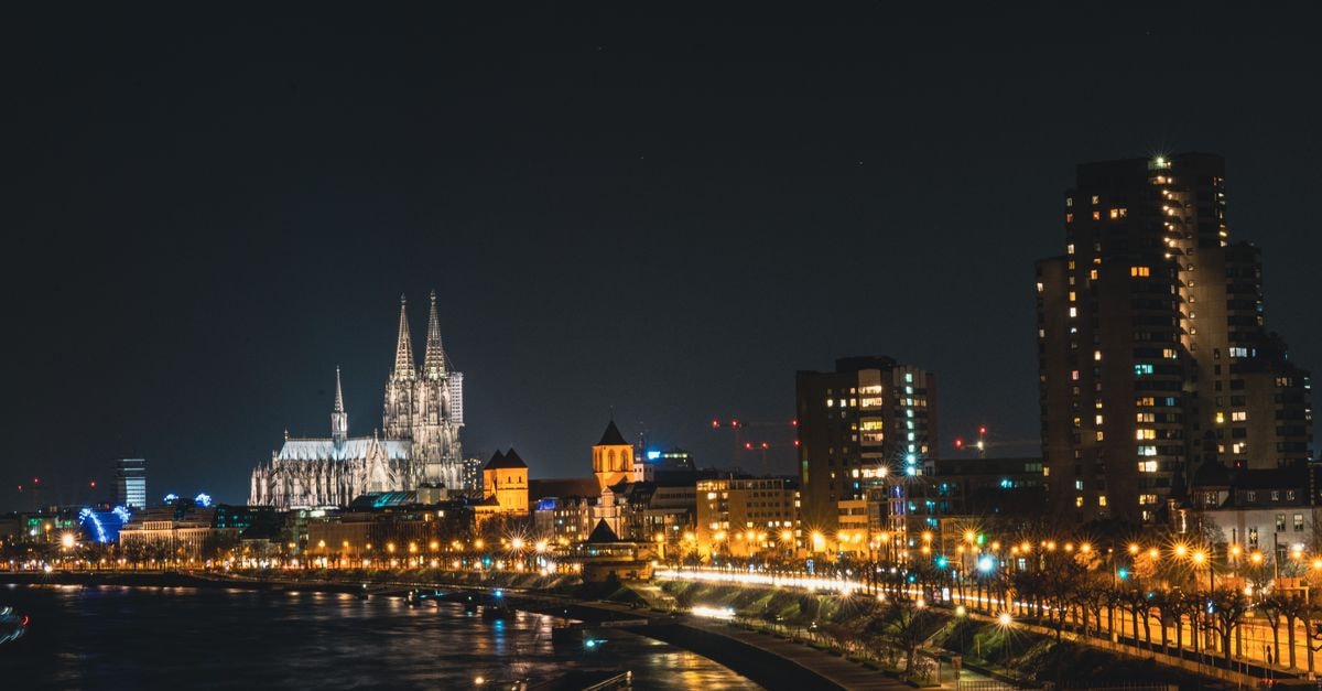 CityClass Hotel am Dom in Cologne: Steps From the Rhine Dramatic night view of Cologne Cathedral and city skyline reflecting on the Rhine River, Germany.