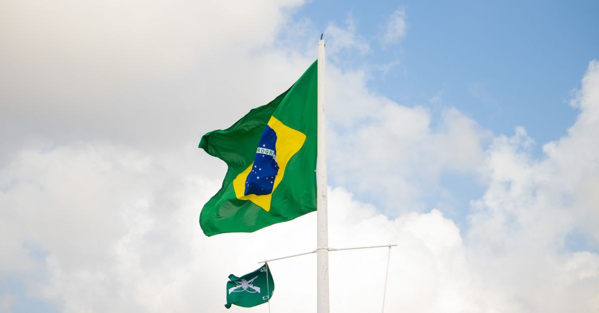 The Brazilian flag waving against a bright sky in Aracaju, Brazil.