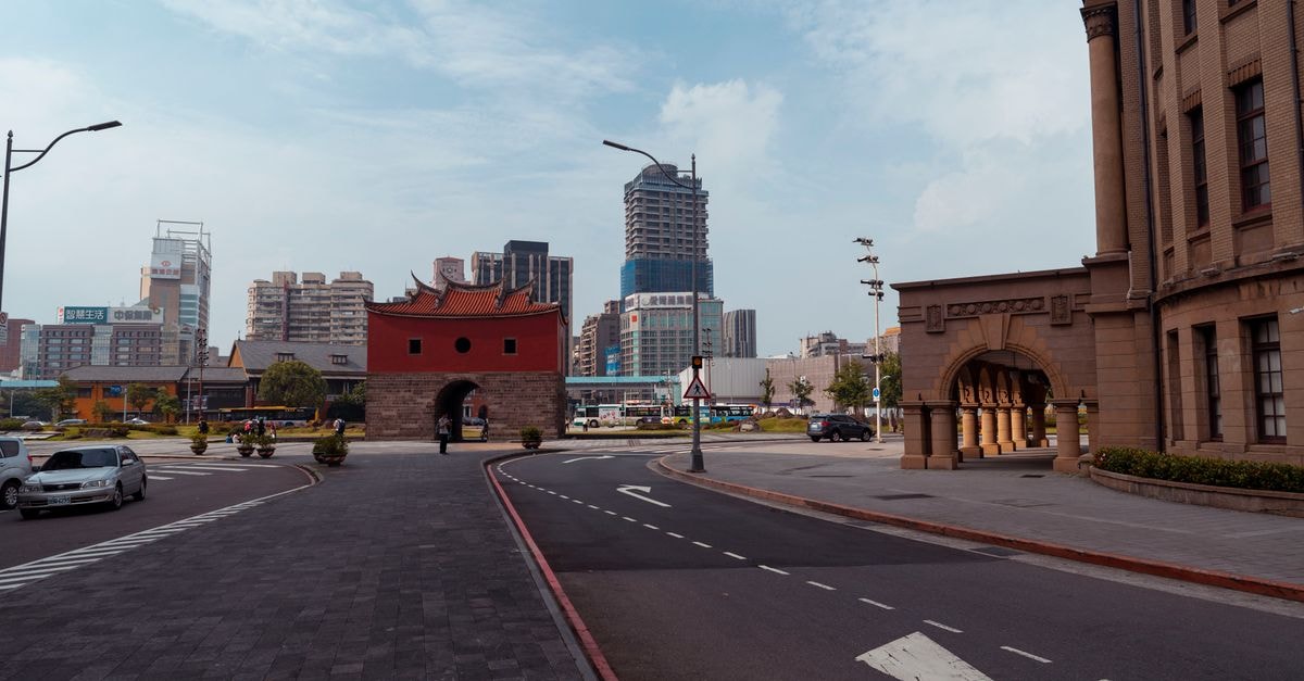 Taipei North Gate and cityscape with modern buildings under a bright sky.