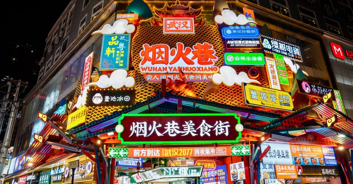 Wuhan Travel Guide: A Central China Hub Worth Pausing For Colorful neon signs illuminate Wuhan's bustling snack street at night.