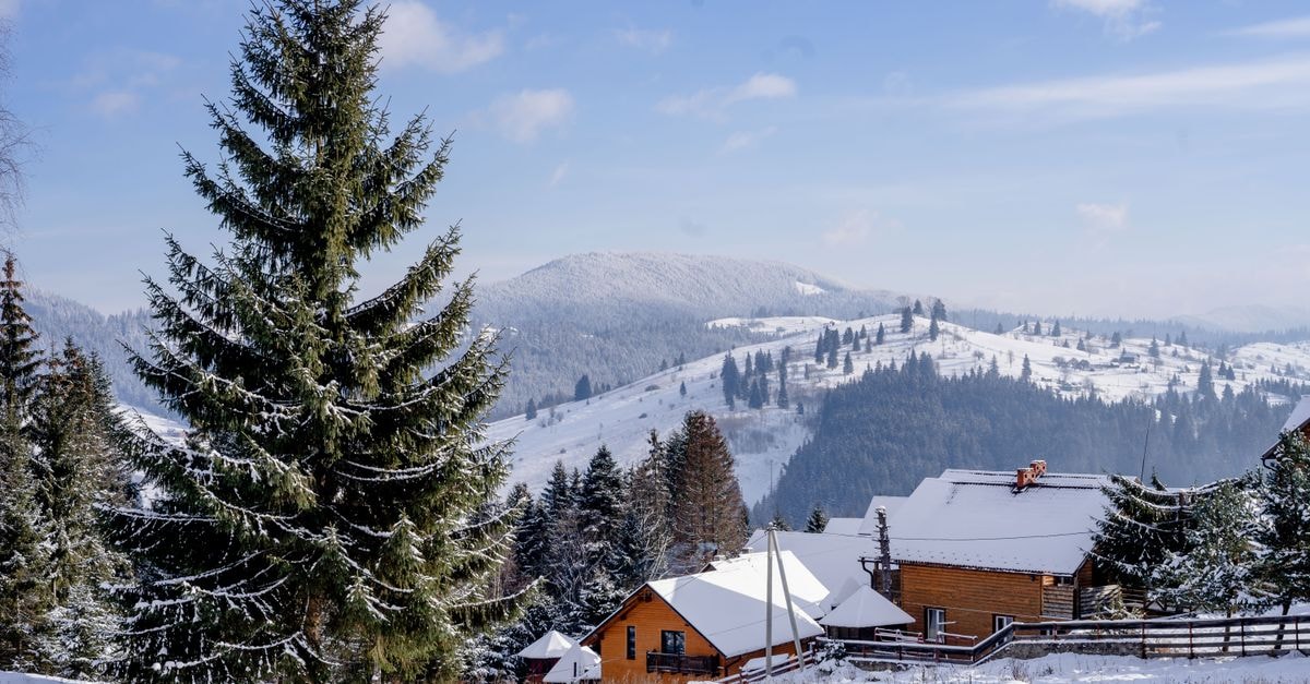 Hotel Bucovina in Suceava: Romanian Tradition and Refined Hospitality Snow-covered cabins nestled in the Romanian hills with a picturesque winter setting.