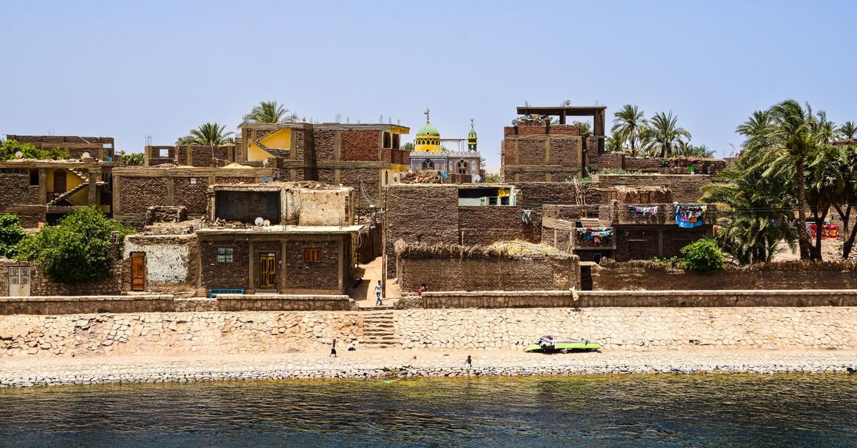 Néma Travel Guide: Planning Tips, Costs and Things to Do Charming view of a traditional village with historic architecture on the Nile Riverbank under a clear blue sky.