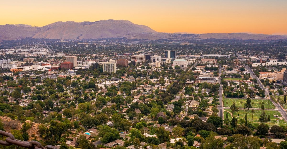 Fairfield Inn & Suites in Santa Ana: Newport Avenue Address with Suite-Style Layouts Stunning aerial view of Riverside cityscape, with mountains in the background under a twilight sky.