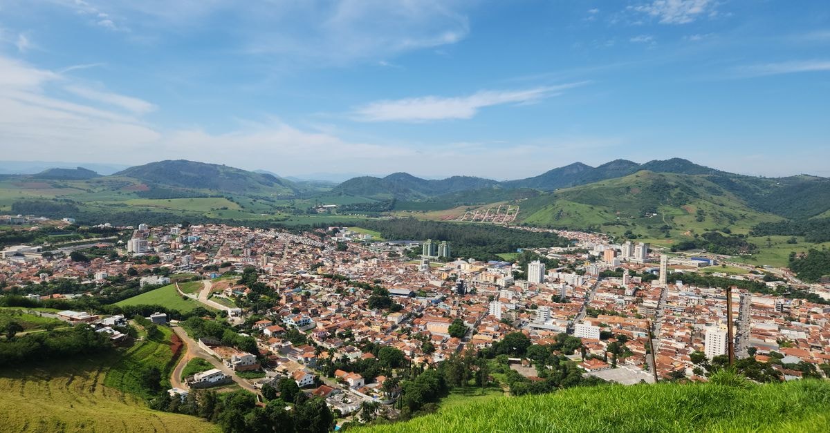 Campinas Travel Guide: Practical Things to Know Before You Go Aerial view of a scenic town nestled among lush green hills under a clear blue sky.