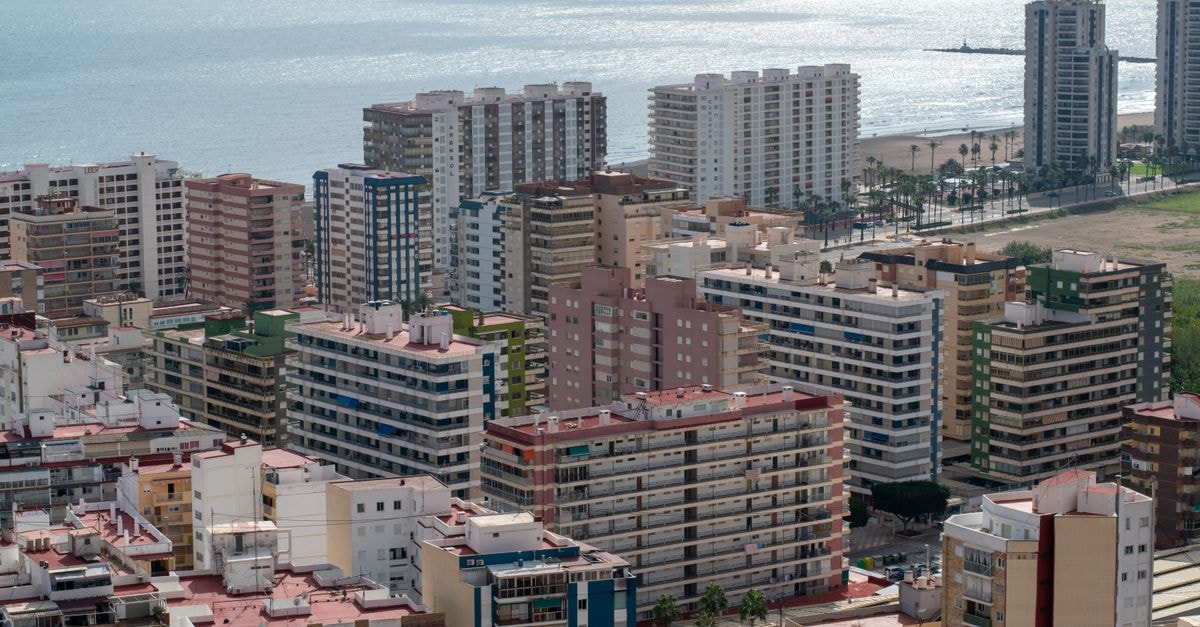 Meliá Plaza Valencia: Plaza del Ayuntamiento Stay with Soundproofed Rooms Stunning aerial view of Valencia's coastal cityscape with modern architecture and the shimmering sea.