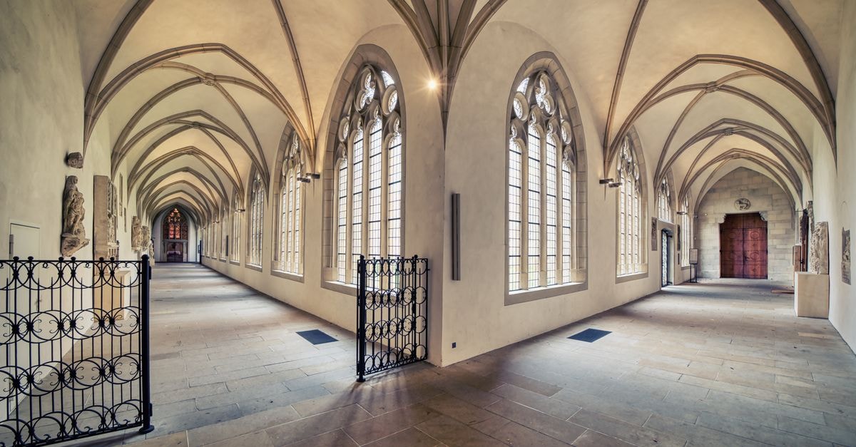 Münster Travel Guide: A Quiet Charmer in North Rhine-Westphalia Explore the serene gothic architecture of Münster Cathedral's cloister with its exquisite arched ceilings and elegant corridors.
