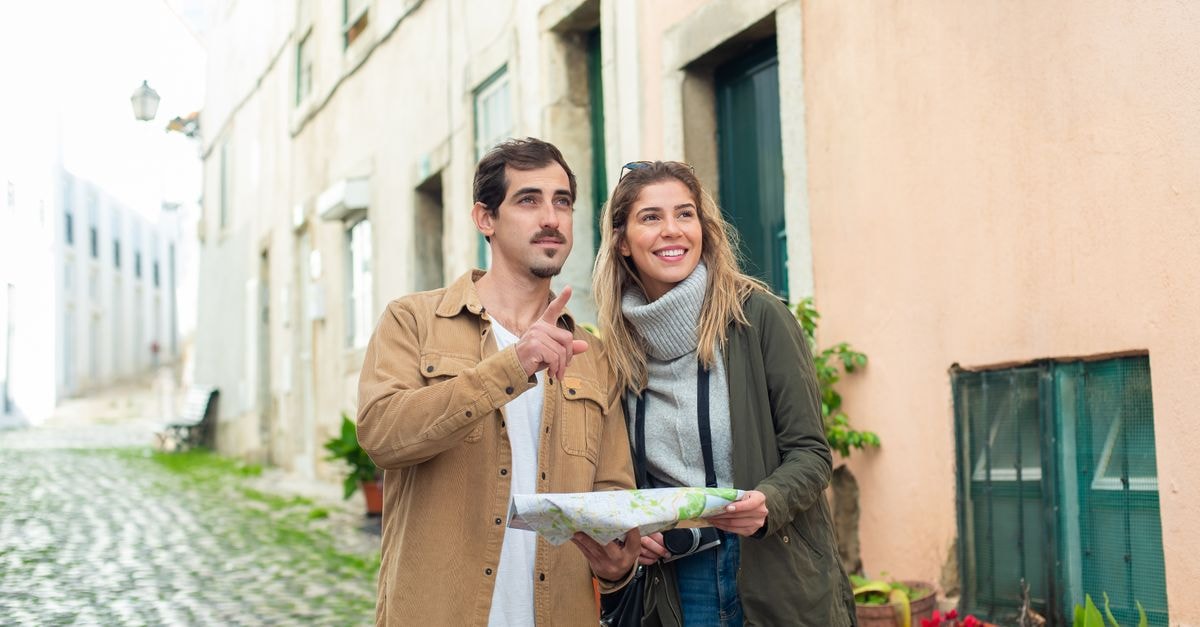 Viseu Travel Guide: A Quiet Hilltop City of Gardens and Slow Meals Happy couple exploring a historic city using a map, enjoying a travel adventure together.