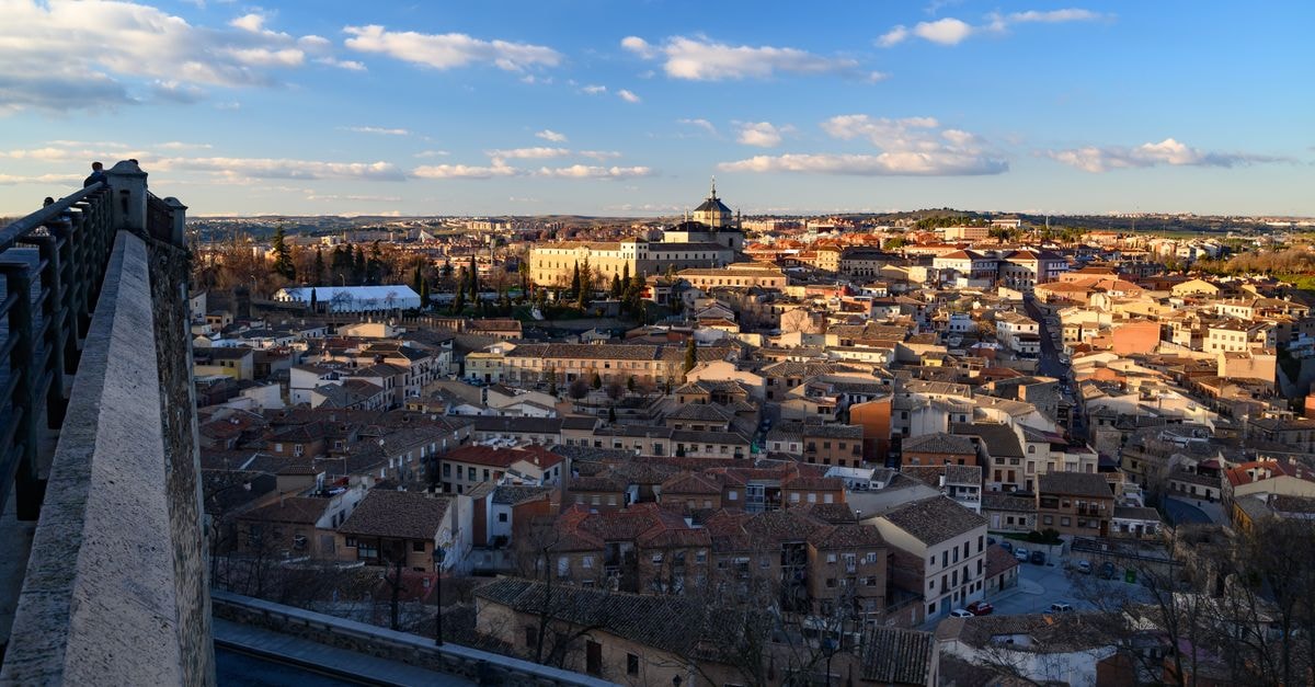 Panoramic view of Toledo's historic architecture under a bright blue sky.