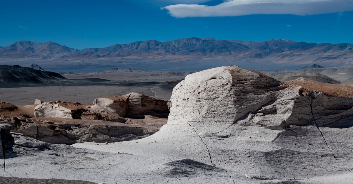 Hotel Pucará in Catamarca: Old-House Calm Meets Modern Comfort Beautiful desert scene with unique rock formations and distant mountains under a vibrant blue sky.