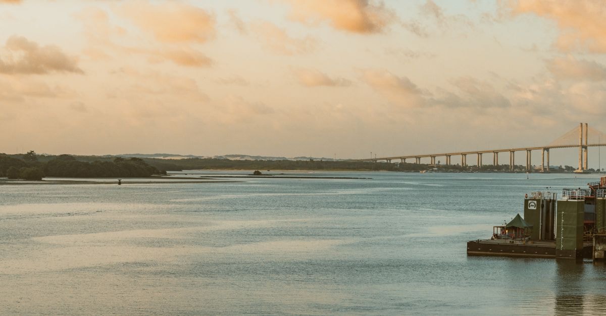 Serene view of Ponte Newton Navarro at sunset in Natal, Brazil. Calm waters and vivid sky.
