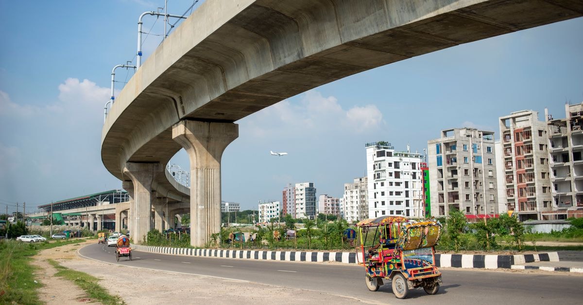 Bhatpara in North 24 Parganas: A Riverside City on the Hooghly Colorful vehicles beneath a concrete overpass in Dhaka, showcasing urban development.