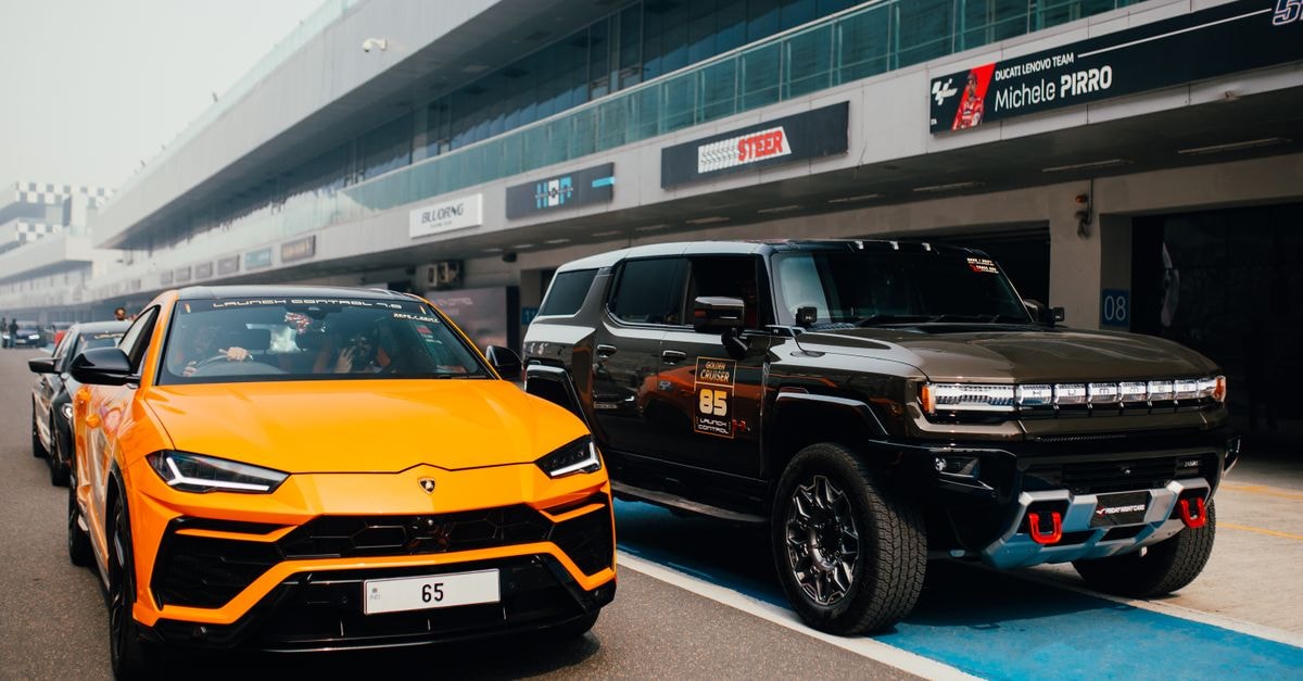 Radisson Blu Hotel Greater Noida: Gateway Near India Expo Mart Orange Lamborghini and Black SUV parked on racetrack in Greater Noida, India.