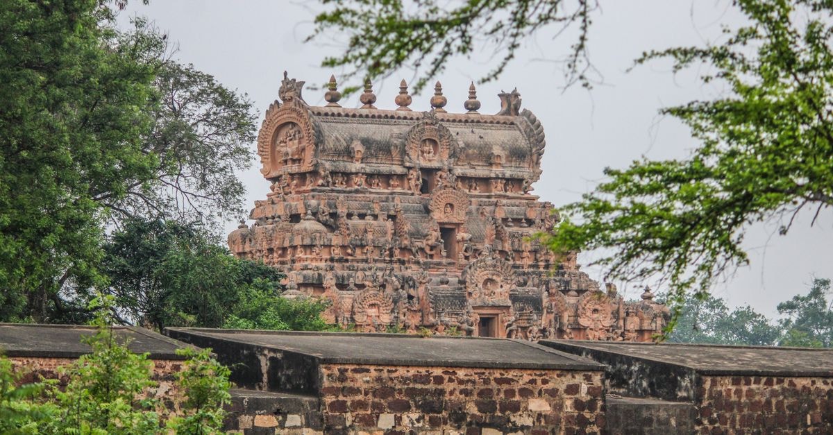 View of the intricate Brihadeeswarar Temple in Thanjavur, surrounded by lush greenery.