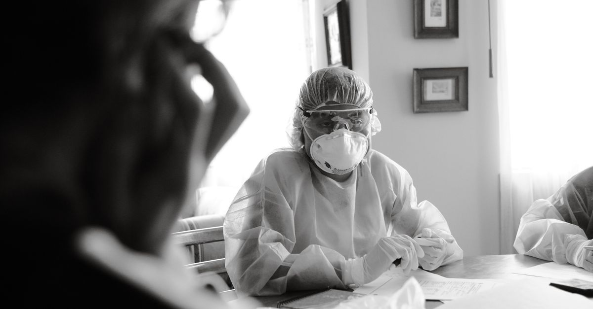 DRC Ebola outbreak strains unpaid health workers as WHO warns of potentially devastating crisis A black and white image of healthcare workers wearing protective suits and masks indoors.