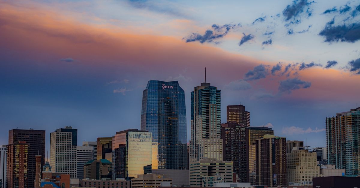 Stunning view of Denver's cityscape with skyscrapers under a colorful sunset sky.