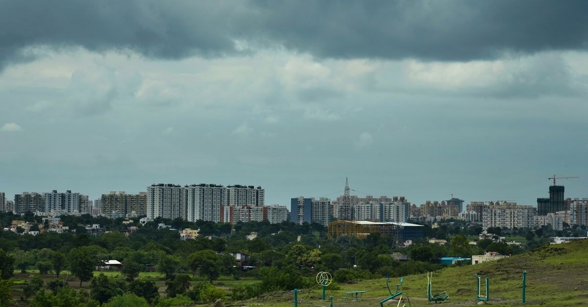 Ginger Hotel in Pimpri-Chinchwad: A Practical Base on Service Road City skyline of Pune, Maharashtra with lush greenery and open gym equipment under dramatic cloudy skies.