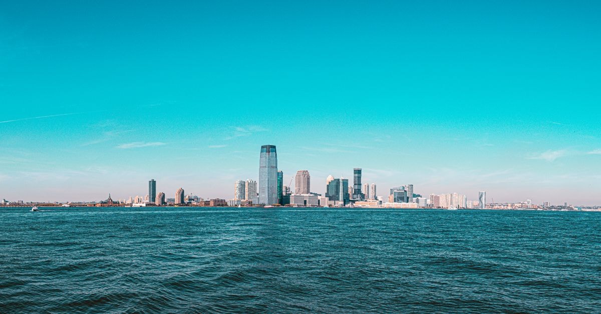 Jersey City Travel Guide: Waterfront Views, History, and Easy Manhattan Access Panoramic view of Manhattan skyline with modern skyscrapers under a clear blue sky.