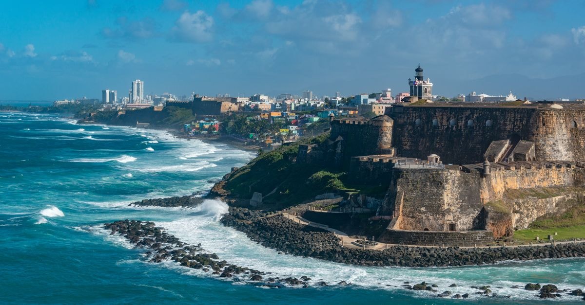 Villa Herencia Hotel in Old San Juan: Colorful Retreat on Cobblestone Streets Scenic view of El Morro fortress and vibrant San Juan coastline, Puerto Rico.
