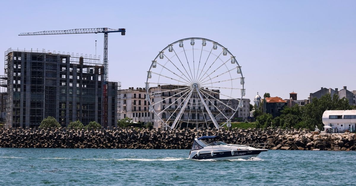 Constanța travel guide: Black Sea rhythm without the rush A sunny day view in Constanța with a ferris wheel, construction site, and a boat in the foreground.