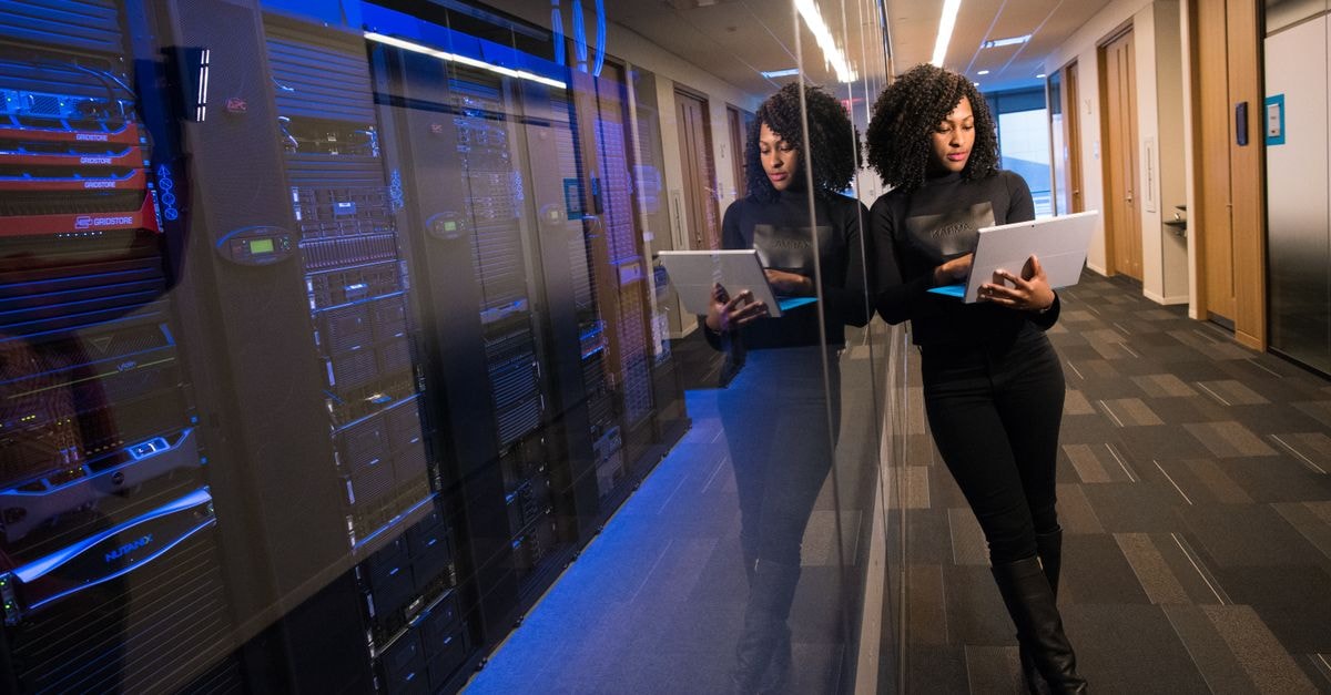Stereotaxis: Robotic Endovascular Niche, but the Cash Engine Has Not Started A woman using a laptop navigating a contemporary data center with mirrored servers.
