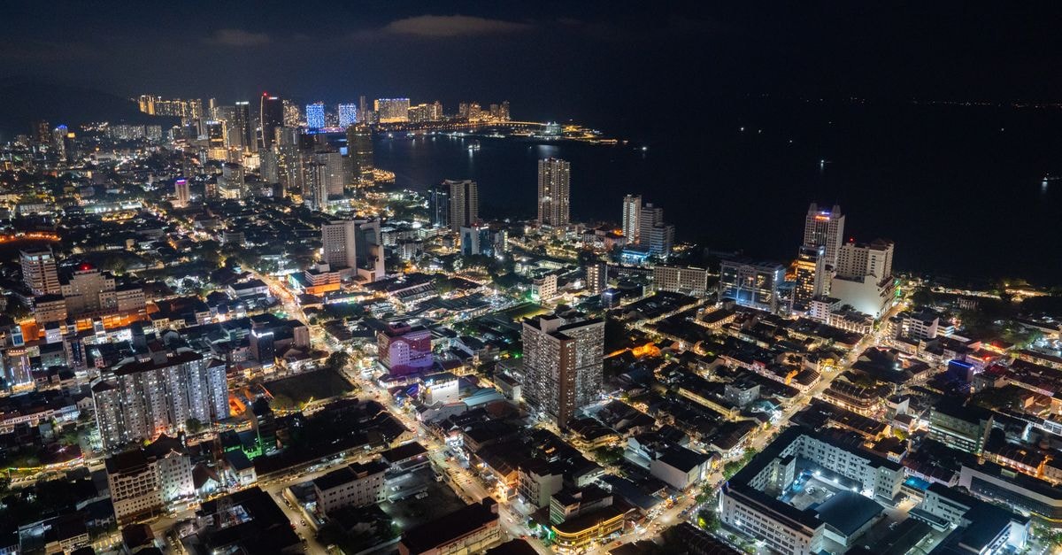 Aerial view showcasing the vibrant urban landscape and skyline of Penang, Malaysia at night.