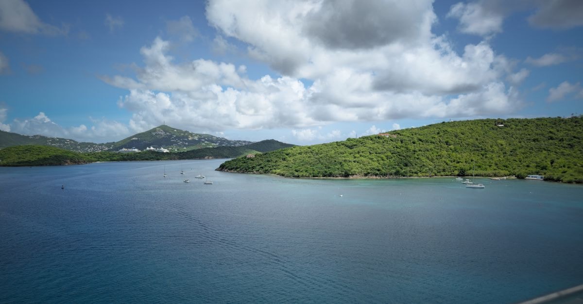 Bridgetown Travel Guide: Caribbean Charm on Carlisle Bay A breathtaking view of a Caribbean bay with boats and lush green hills on a sunny day.