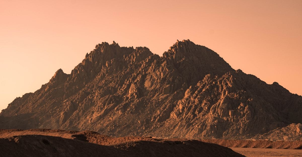 Dramatic sunset view of rugged mountains in Sharm El-Sheikh, Egypt, with warm hues.