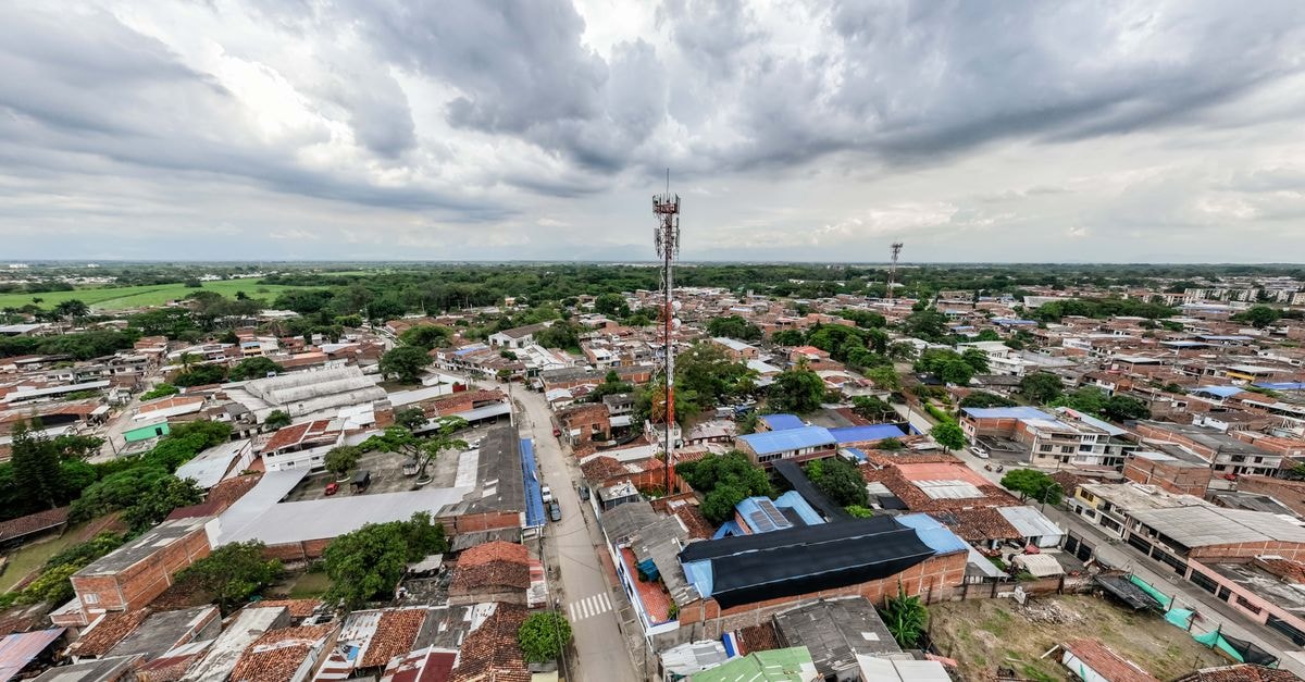 Aerial view of a sprawling urban area under a dramatic cloudy sky.