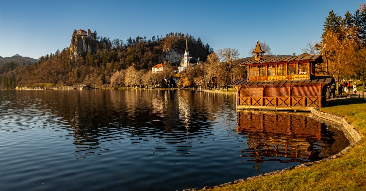 Hotel Lovec in Bled: A Century-Old Lakeside Retreat Tranquil autumn view of Lake Bled with Bled Castle and Church in Slovenia.