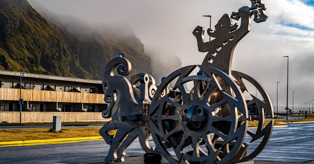 Dynamic sculpture of Thor's chariot in Vik, Iceland with a misty mountain backdrop.