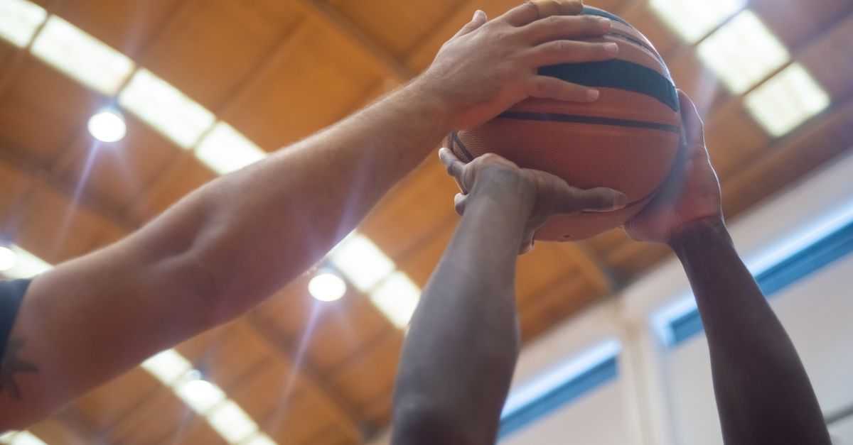 WNBA News: Cunningham Stirs Trans Athletes Debate; Mystics Emerge as Playoff Threat Close-up shot of players competing for the basketball in an indoor court.